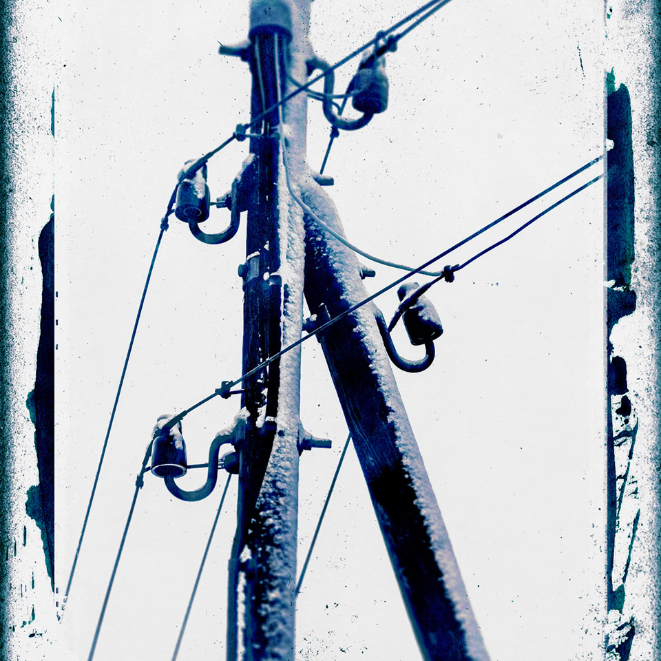 Poteau électrique avec câbles et isolateurs, encadré par un bord décoratif.