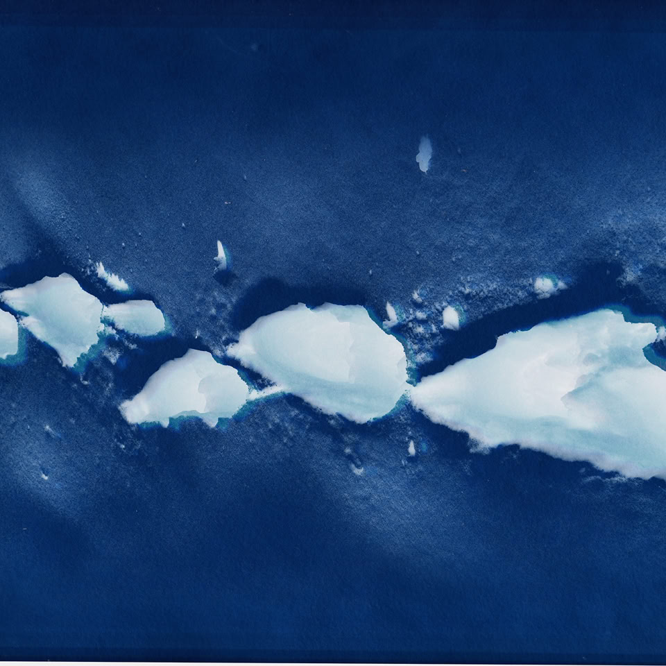 Des morceaux de glace flottant sur une étendue d'eau bleue.