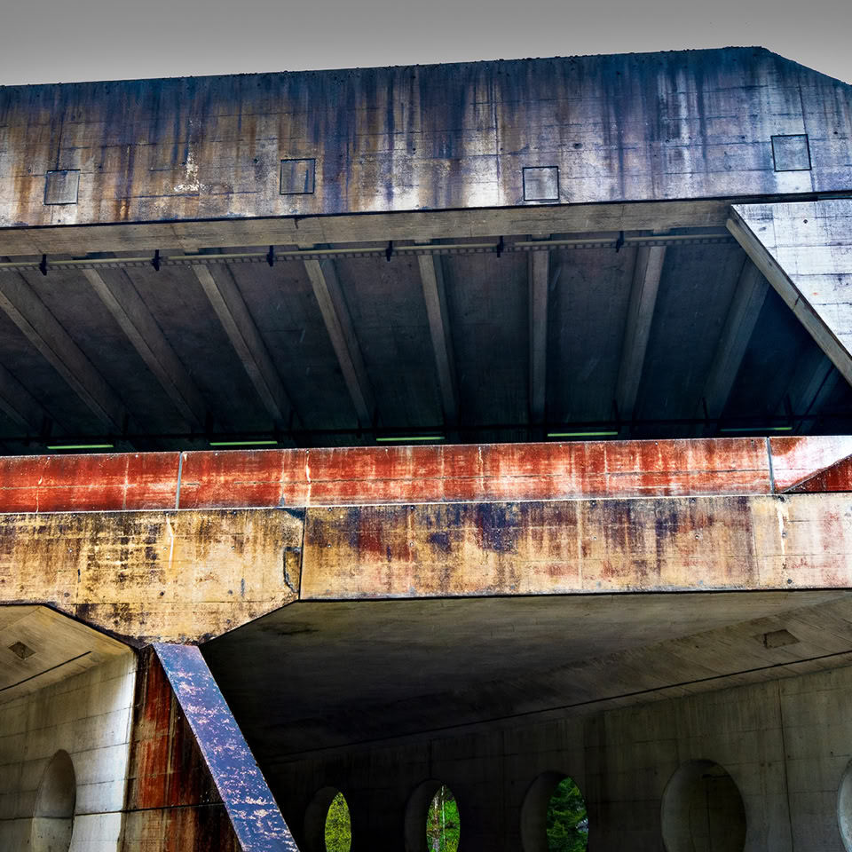 Pont en béton avec des traces de rouille et des piliers visibles en dessous.