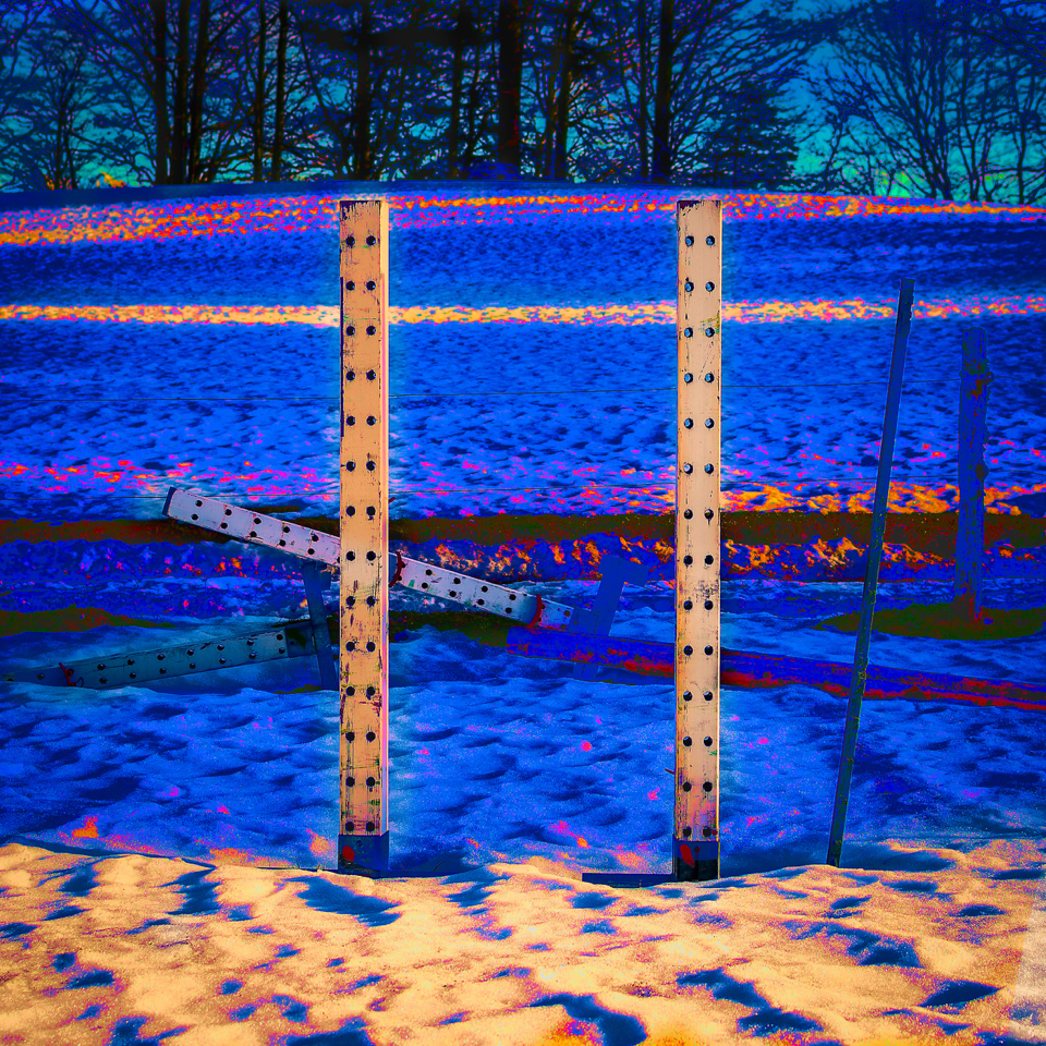 Structure métallique colorée sur fond de paysage enneigé avec des arbres à l'arrière-plan.