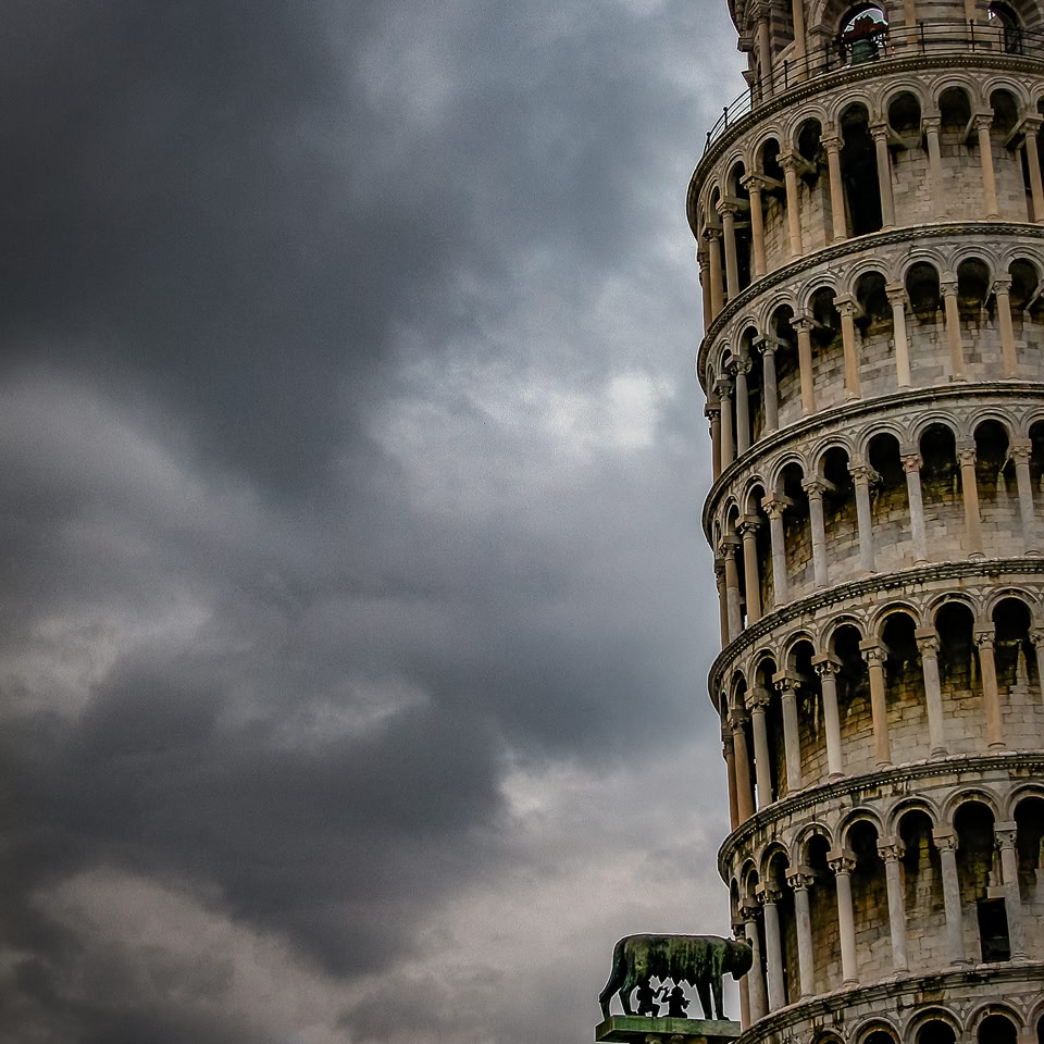 Tour penchée avec ciel nuageux en arrière-plan.