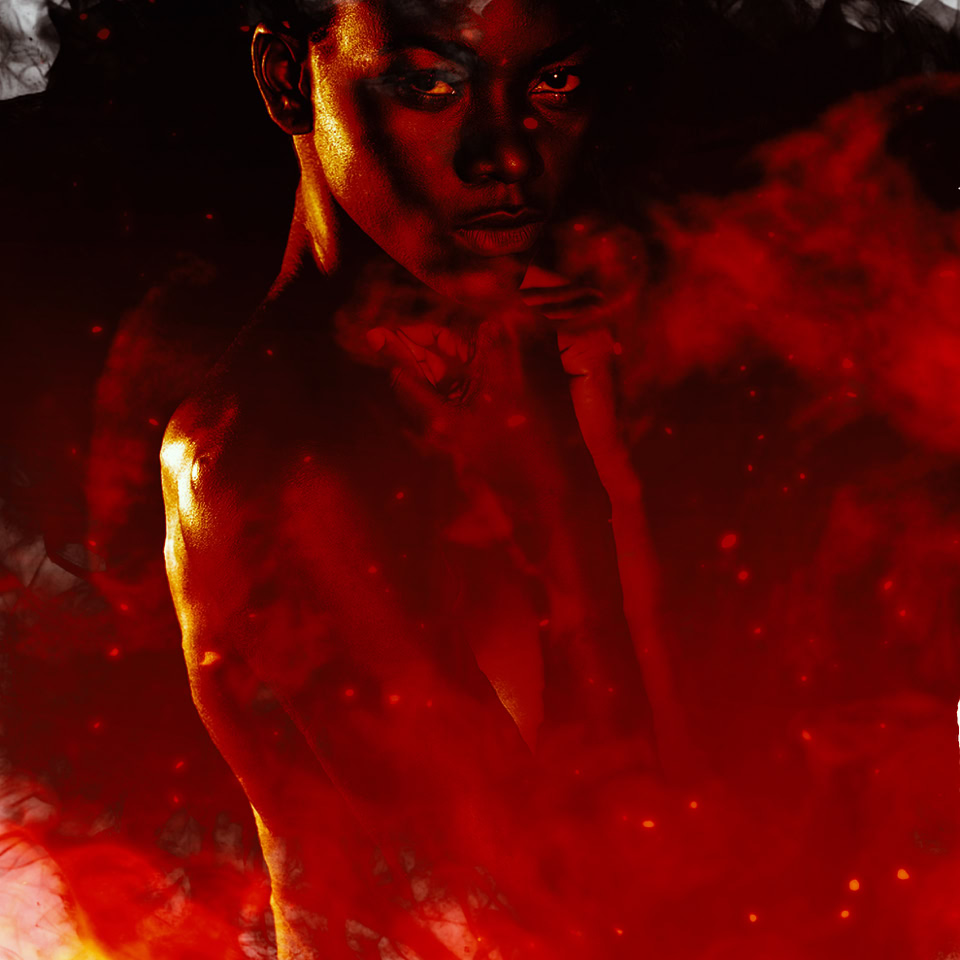 Personne entourée de fumée noire et rouge, avec des effets lumineux intenses.